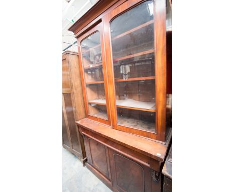 A Mid Victorian mahogany bookcase, the upper section fitted with two glazed doors opening to reveal four adjustable shelves, 