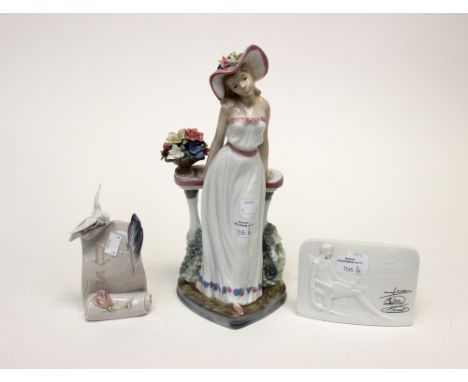 A Lladro collectors', Society signed plaque with a further Lladro Society plaque and a Nao girl wearing a hat. (3)