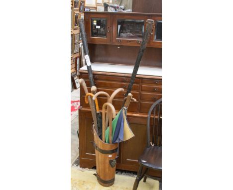 A stick bucket with umbrellas and walking sticks.