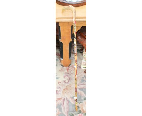 A walking cane with a horn handle shaped as a Flamingo head, painted and grooved stick.