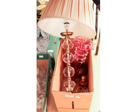 A collection of rose glass and a table lamp.