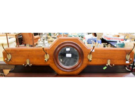 An early 20th Century wall hanging coat and hat stand, with a central circular bevelled edge mirror, width 102cm.