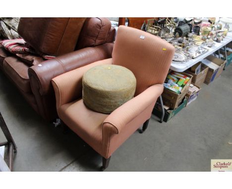 An upholstered armchair together with an upholstered pouffe 
