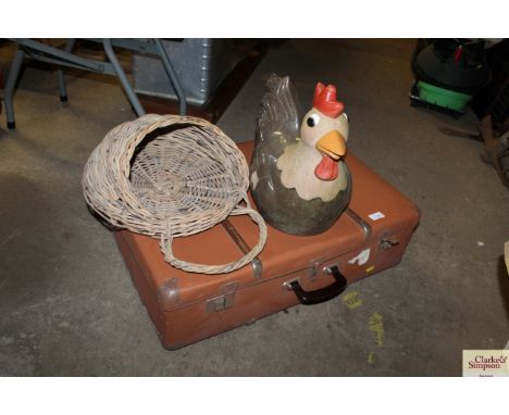 A large ceramic chicken; wicker egg collecting basket and two cases