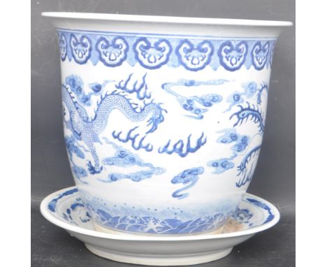 A large early 20th century Chinese oriental blue and white planter and charger dish. The body being hand painted with Chinese
