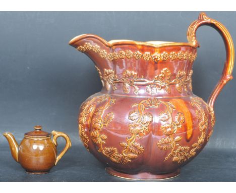 A large 19th century Victorian Staffordshire Yorkshire treacle glaze pitcher with oak leaf decoration in relief, together wit