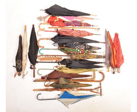 A large collection of vintage 20th century walking sticks and umbrellas to include a barely twist riding crop, 1950s tartan u