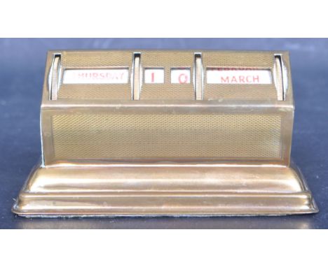 An early 20th century British made brass perpetual desk calendar of domed form raised on a plinth base with engine turned dec