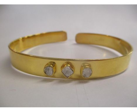 A silver gilt bangle set with three diamonds Location: CAB