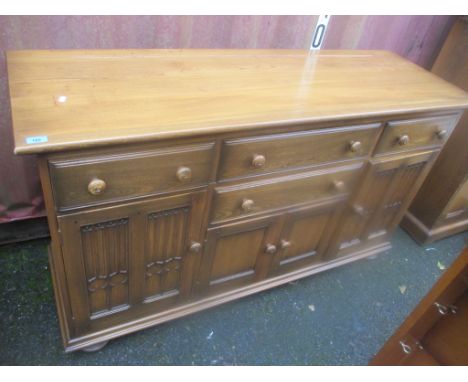 An Ercol elm Golden Dawn sideboard having drawers and cupboards below 89 h x 155cm w