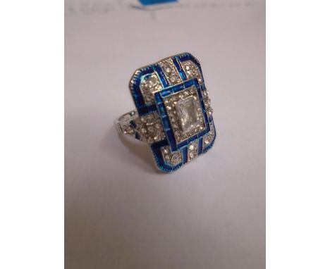 In the Art Deco style, a plaque ring set white paste stones and blue enamel, UK ring size P/Q