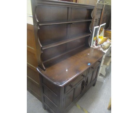 A mid 20th century dark Ercol dresser having a plate rack above drawers and cupboards, 162 h x 123cm w