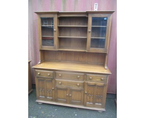 An Ercol elm Golden Dawn dresser having display shelves above drawers and cupboards 200 h x 155cm w