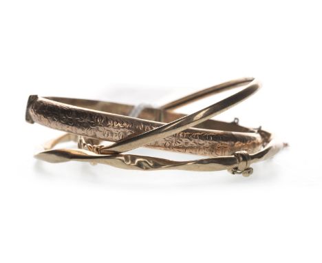 NINE CARAT GOLD ENGRAVED BANGLE, with foliate decoration to the front panel, along with a twist bangle marked 9KT and an unma