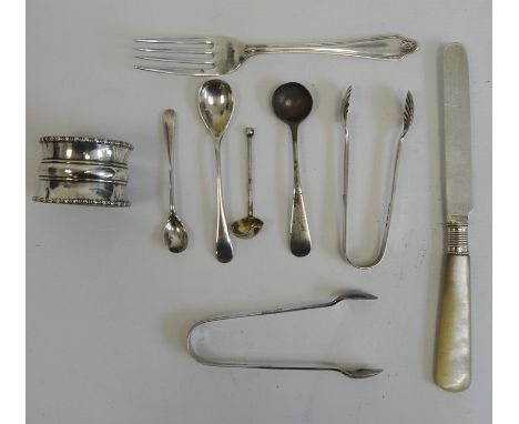 Silver napkin ring, a small silver tea fork, two silver sugar nips, miniature spoons and a mother-of-pearl and silver tea kni