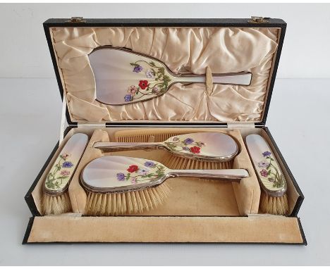 1930's silver and enamel mounted dressing set comprising of four brushes and mirror, cased, the pale yellow and purple enamel