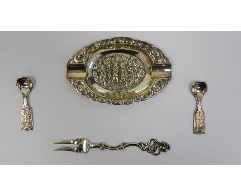 Continental white metal ashtray with embossed decoration, two Norwegian salt spoons marked '60 GR HS' and a pickle fork marke