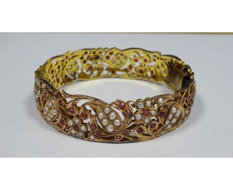 Indian(?) gold ?, ruby and seedpearl bangle, pierced scroll and floral decoration, unmarked, 42.5g total , inside diameter is