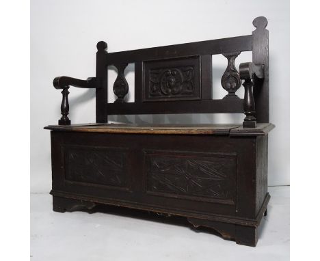 Stained oak bench, carved back above lift up seat, the whole raised on bracket supports and an oak framed octagonal mirror (2