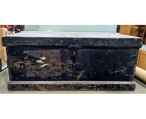 Early 20th century black painted pine trunk with iron hasp and some shipping labels