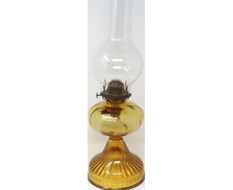 An American amber glass oil lamp, with chimney, H: 53 cm. Not available for in-house P&amp;P 