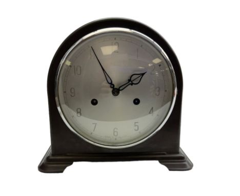 Enfield- English 1950's 8-day mantle clock in a round topped brown Bakelite case on splayed feet, with a glazed chrome bezel 
