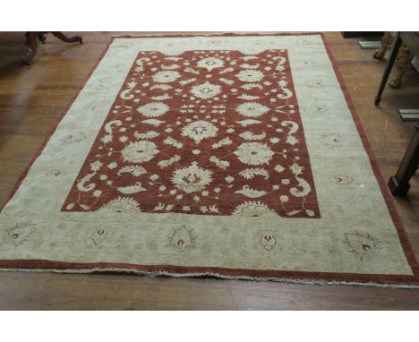 A RECTANGULAR WOOL RUG, the gold ground with brown central panel decorated with beige foliates with fringing,300cms x 240cms.