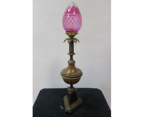 A REGENCY STYLE GILT BRASS AND FAUX TABLE LAMP of circular tapering form headed by a cut glass ruby shade on triangular plint