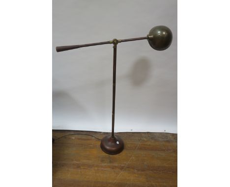 AN EARLY 20th CENTURY LEATHER UPHOLSTERED ADJUSTABLE STANDING LIGHT, with brass mounts and domed shaped shade on a circular b