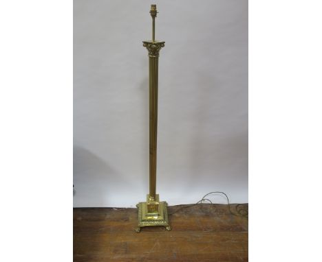 A GEORGIAN STYLE BRASS STANDARD LIGHT, in the form of a corinthian column on rectangular base with paw feet,150cms high.