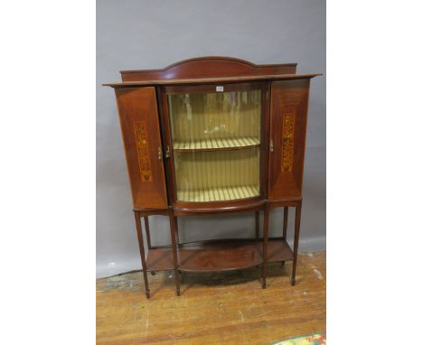 AN EDWARDIAN MAHOGANY INLAID DISPLAY CABINET, the raised back above the breakfront bowed top with a single glazed cupboard do