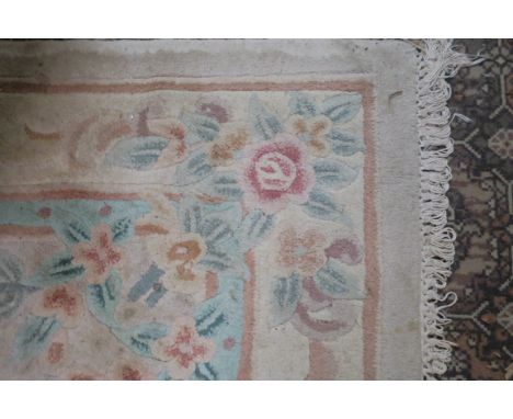 A CHINESE WOOL RUG, the beige ground with central floral panel within a conforming border, 244cms x 167cms.