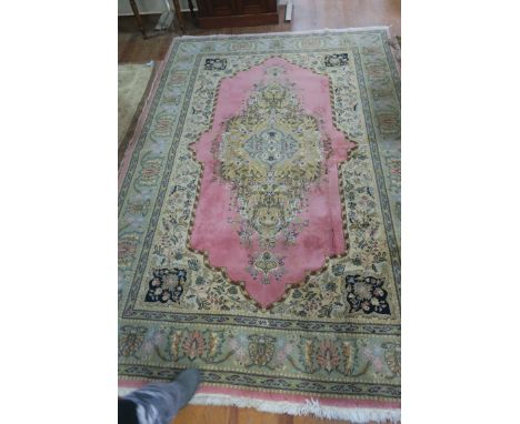 A WOOL RUG, the light pink and beige ground with central floral panel within a conforming border,285cms x 190cms.