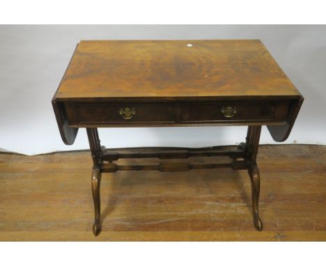 A WALNUT CROSSBANDED SOFA TABLE, rectangular hinged top, above two frieze drawers on ring turned columns, on platform base wi