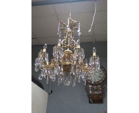 A CONTINENTAL STYLE GILT BRASS TEN LIGHT CHANDELIER, the acanthus shaped corona hung with pendant drops above the scrolled an