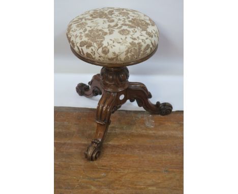 A WILLIAM IV ROSEWOOD PIANO STOOL, the circular upholstered top raised on a carved pod with foliate scrolled hipped tripod su