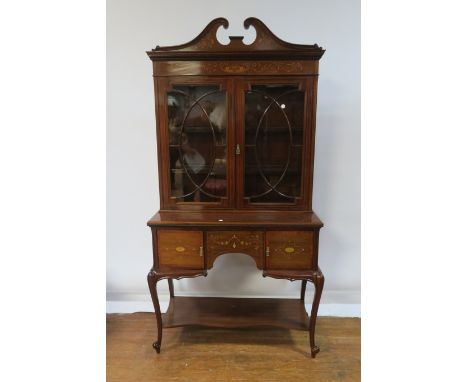 AN EDWARDIAN MAHOGANY AND MARQUETRY INLAID DISPLAY CABINET, BY EDWARDS & ROBERTS, the broken swan neck pediment inlaid with f