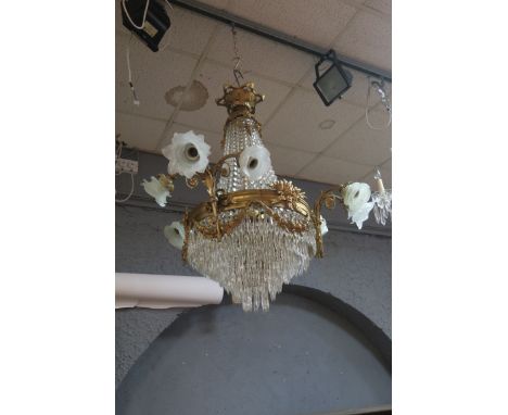 A CONTINENTAL STYLE GILT BRASS AND CUT GLASS TIER DROP CHANDELIER, the foliate corona issuing facetted chains above the circu