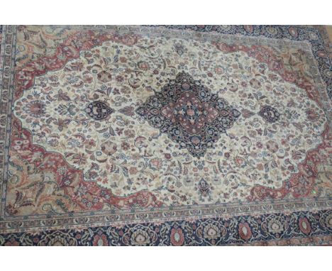 A RECTANGULAR WOOL RUG, the salmon pink and blue ground decorated overall with foliate motifs with rectangular central panel 