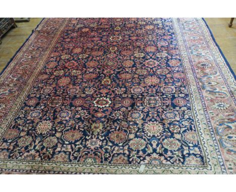 A FINE WOOL RUG, the light pink and indigo ground with central stylised floral panel within a conforming border, (slight fadi