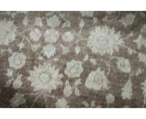 A WOOL RUG light brown with beige field with central floral panel within a conforming border 240cm X 170cm 