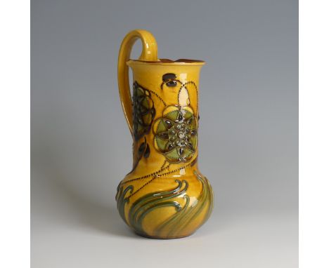 Frederick Braddon for C. H. Brannam pottery Jug, with bulbous base and cylindrical neck, decorated in relief paintwork with a