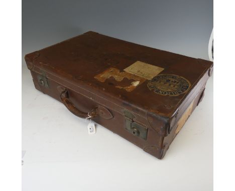 A vintage leather Suitcase, with maker's label for 'Natal Trunk Works Ltd, Manufacturers, Durban', and bearing luggage labels