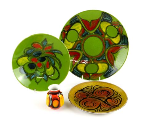 Poole pottery, a Delphis plate in red, yellow and turquoise on a green ground, diameter 35cm, another similar, diameter 27cm,