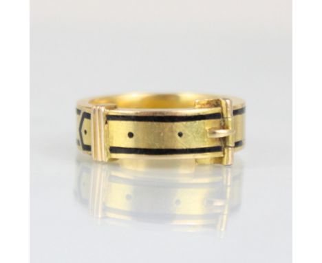 A 19th century enamel mourning ring, formed as buckle with black enamel border, hinged to reveal plaited hair, engraved to in