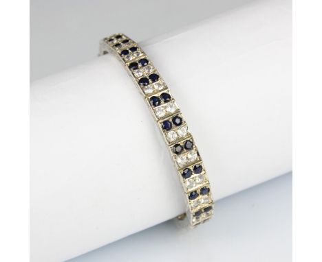 An Art Deco style blue and white sapphire bracelet, the graduated white metal square panel set with blue and white round cut 