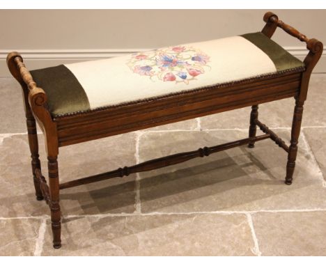 An Edwardian walnut duet stool, the hinged tapestry work seat opening to twin compartments, flanked by ring turned and incise
