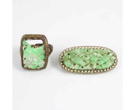 An early 20th century jade and paste seed pearl brooch, the oval carved jade panel depicting birds amongst foliage, within op