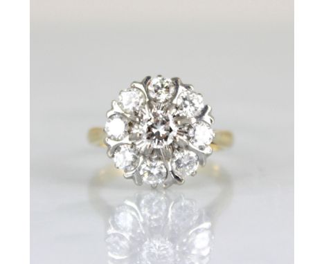 An Edwardian style diamond cluster ring, the raised central round cut diamond within surround of eight smaller round cut diam