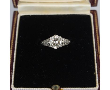 An early 20th century Art Deco diamond solitaire ring, the central transitional cut diamond within white metal claw setting e